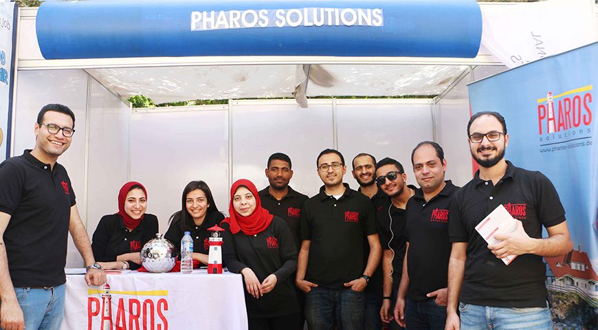 Pharos Solutions team standing in front of their booth at the job fair in the Faculty of Engineering, Alexandria University
